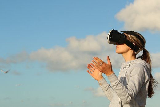 Frau mit Head Mounted Display unter freiem Himmel.